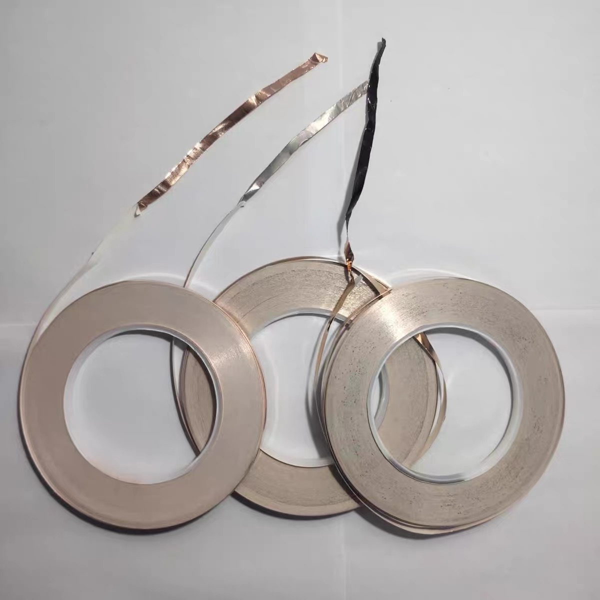 Three stained glass copper foil rolls showing backing options